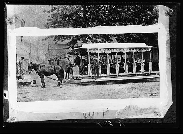 A horse drawn cart in the city sreets